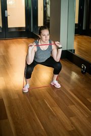 Squatting with resistance band for upper extremity